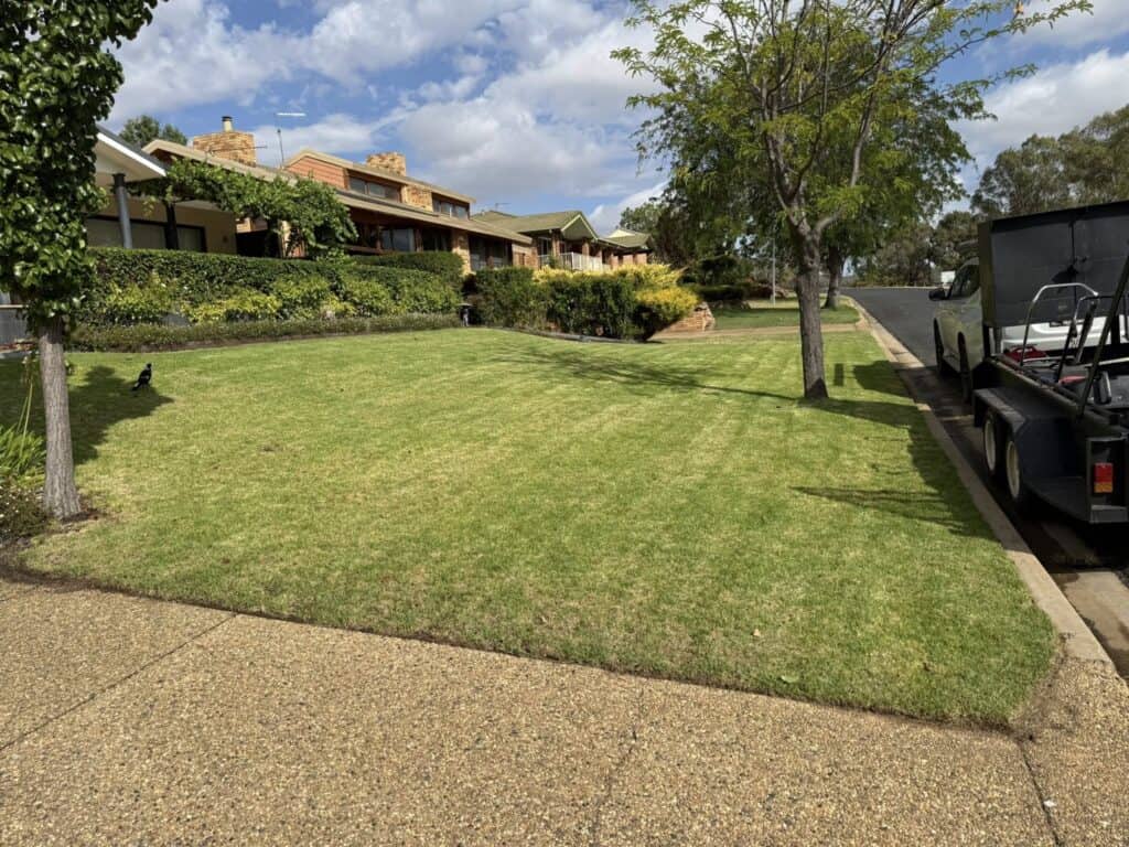 Neat suburban brick homes with manicured lawn and trees