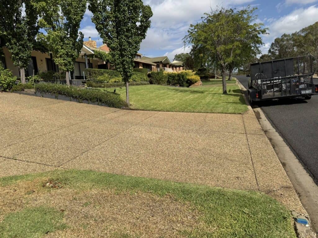 Suburban homes with manicured lawn and parked trailer